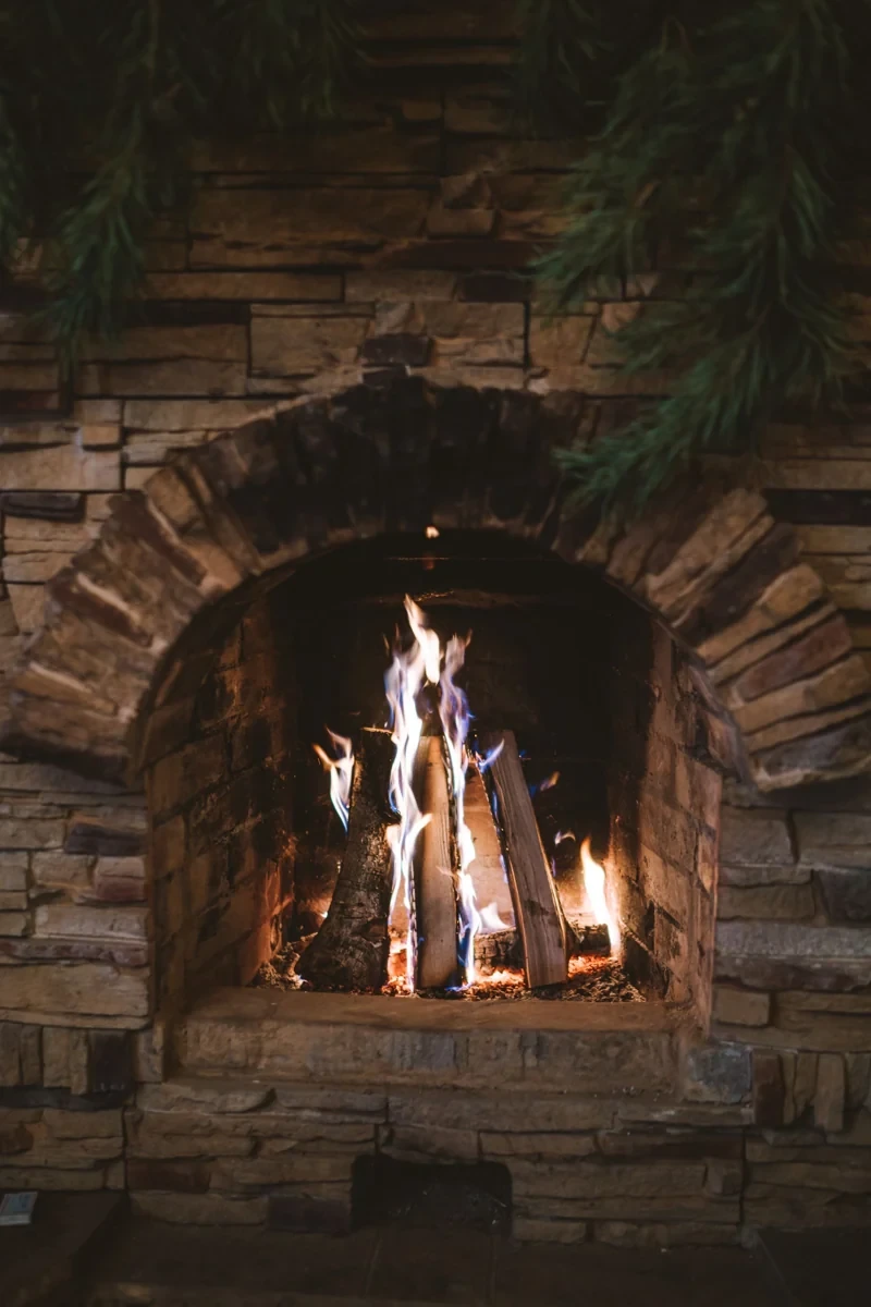 Fire burning in a stone hearth, used as illustrative fireplace photography